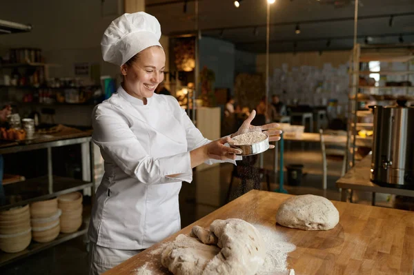 Vrolijk Lachende Vrouwelijke Bakker Uniform Zeug Meel Door Keukenzeef Deeg — Stockfoto