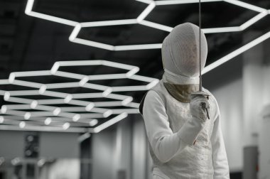 Eğitimde koruyucu giysiler ve miğfer giyen kılıç sporcusu portresi. Eskrim geleneksel selamlama. Profesyonel eskrim turnuvası