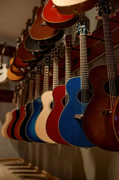 ミュージックショップの壁に掛けられたアコースティックギター弦楽器のラックに焦点を当てました 市場販売 — ストック写真