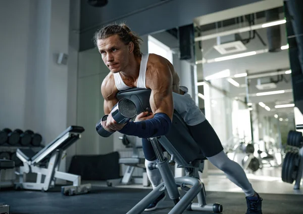 ジムでフィットネスベンチトレーニング筋肉にダンベルを持ち上げるハンサムな強い男 ボディビル運動とウェイトリフティングワークアウトのコンセプト — ストック写真