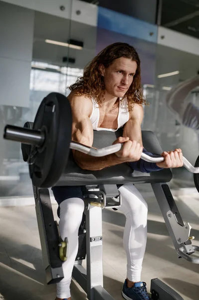 強い男ボディビルダーポンプ筋肉作業でベルオンスコットベンチでジム — ストック写真
