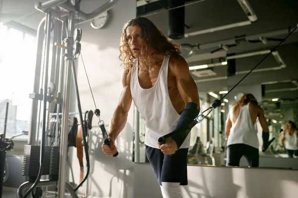 ジムでトレーニング機器の拡大と運動抵抗バンドを行う強力な筋肉スポーツマン — ストック写真