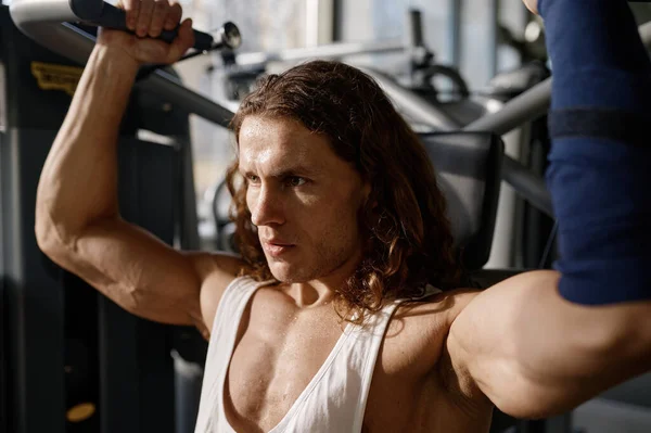 ジム機器に強い筋肉ボディトレーニングを持つ深刻な集中スポーツマンの顔にクローズアップビュー — ストック写真