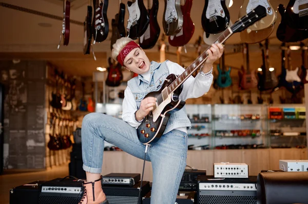 ステレオサウンドアンプに接続されたギターを演奏する感情的なヒップスター女性ロッカー音の満足と賞賛 — ストック写真