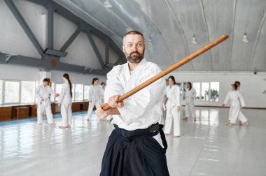 Grup eğitiminde tahta kılıçlı aikido ustasının portresi. Bambu boken ile dövüşmeyi öğrenmek