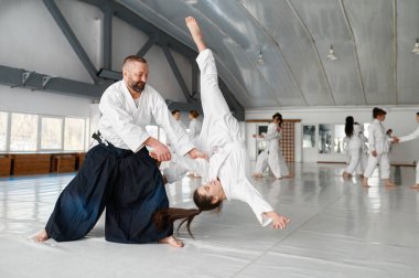 Aikido öğretmeni ve genç kız öğrenci eğitim programı fırlatma ve düşme. Dövüş sanatları pratik kavramı