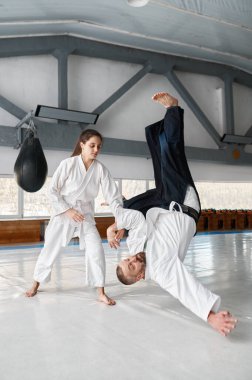 Spor salonunda idman ve savunma eğitimi sırasında aikido öğretmenini yere fırlatan yetenekli bir bayan öğrenci.