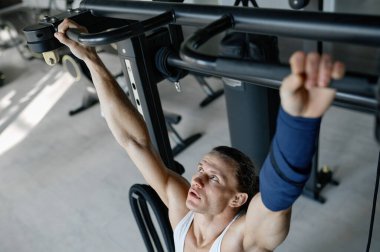 Spor aletlerini kullanarak ağırlık çalıştıran güçlü sporcu eğitimine en iyi bakış açısı. Vücut geliştirme için egzersiz yapan atletik vücutlu bir adam.