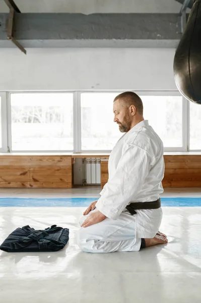 Aikido Meester Zit Vloer Kijkt Naar Zorgvuldig Gevouwen Zwarte Hakama — Stockfoto