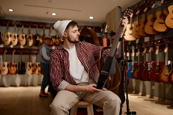 Молодой Человек Выбирает Электрогитару Миллениальный Гитарист Покупает Новый Инструмент Музыкальном — стоковое фото