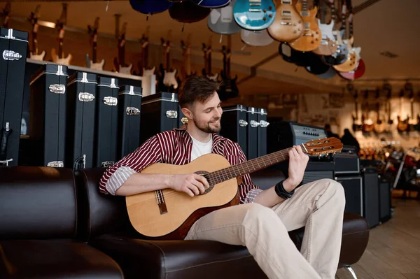 ハッピーヒッパーマンミュージシャン笑顔と文字列楽器店の背景にエレクトリックギターを演奏 — ストック写真
