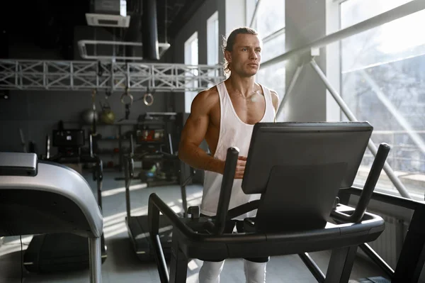 現代のスポーツジムでトレッドミルを走る強い筋肉質の男 固定機械上のアスレチック男性ボディビルダージョギング — ストック写真