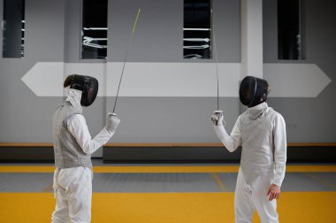 İki eskrim ustası birbirlerinin önünde savaşmaya hazır bir şekilde yükselmiş Rapier 'larla kalıyorlar. Dövüş sporu ve dövüş sanatı konsepti