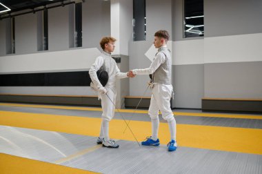 Profesyonel eskrimciler eskrim maçından önce ya da sonra el sıkışıyor. Koruyucu kask maskeli sporcular dövüş sanatları dersinde birbirlerini selamlıyor ya da teşekkür ediyorlar.