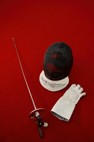 围栏设备的概念 带面具的十字剑和防护头盔 地毯上的竞争制服 — 图库照片