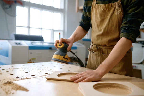 专业的青年木匠在工作台上用偏心磨床抛光条板 轨道砂化的概念 闭包视图 — 图库照片
