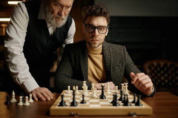 시니어가 남자에게 게임의 규칙을 설명하는 체스를 가르치고 교육적 — 스톡 사진