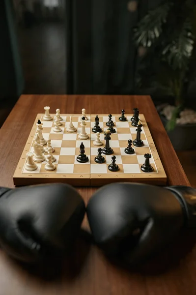 Ξύλινο Τραπέζι Δωμάτιο Μαύρα Δερμάτινα Γάντια Μπόξερ Και Σκακιέρα Chesspieces — Φωτογραφία Αρχείου
