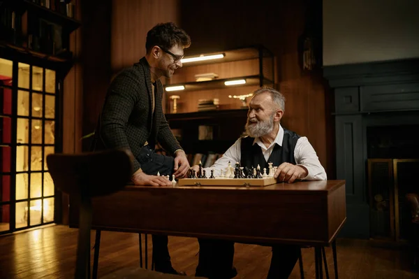 지성적 체스를 두면서 라이브러리에서 시간을 보내고 있습니다 아버지와 사이의 — 스톡 사진