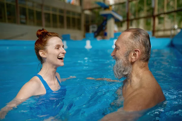 Mutlu Gülümseyen Olgun Bir Adam Havuzda Yüzen Genç Bir Kadın — Stok fotoğraf