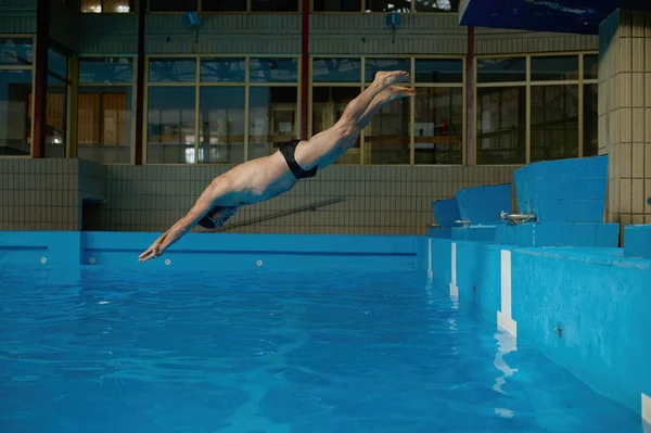 Ανώτερος Άνδρας Πηδάει Στην Πισίνα Ενώ Προπονείται Εσωτερικούς Χώρους Αθλητισμός — Φωτογραφία Αρχείου