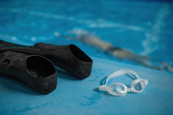 在男子跳水和享受水下训练的同时 在游泳池边观看游泳附件的合影 橡胶拖鞋和护目镜选择焦点 游泳运动员体育俱乐部 — 图库照片