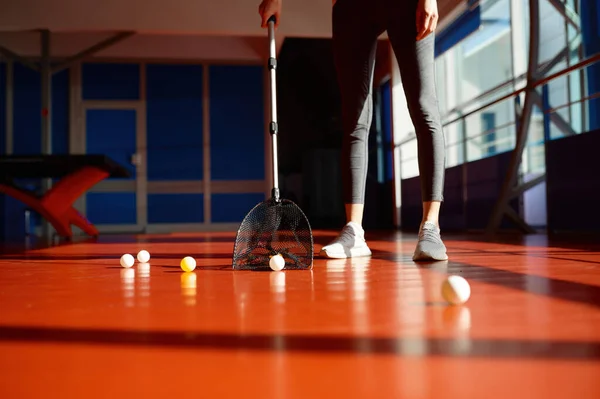 若い女性は 現代的なピンポンスポーツクラブでのトレーニングクラスや競争の後にボールを選ぶ床を掃除 — ストック写真