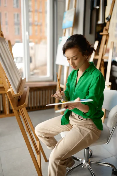 stock image Happy young woman painting brush on canvas at workshop during art lesson class. Creative leisure activity concept