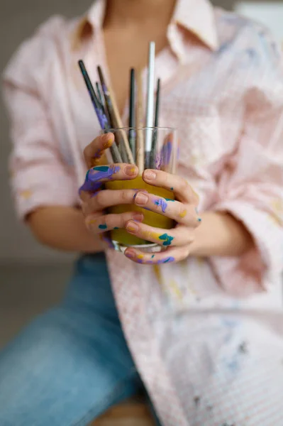 女性アーティスト水のガラスに絵筆機器を洗浄します ドローイングの供給を保持する画家の手に選択的な焦点 時間と芸術の創造性の概念 — ストック写真