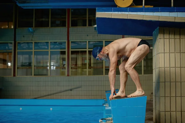 Ανώτερος Αθλητής Στέκεται Στην Εκκίνηση Μπλοκ Ετοιμάζεται Πηδήξει Στην Πισίνα — Φωτογραφία Αρχείου