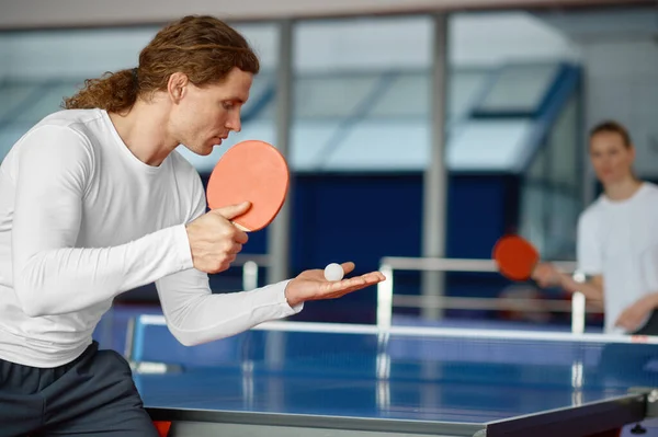 男性と女性はテーブルテニスをプレイし ラケットでボールを提供するスポーツマンプレーヤーに焦点を当てます スポーツと健康的なライフスタイルのコンセプト — ストック写真