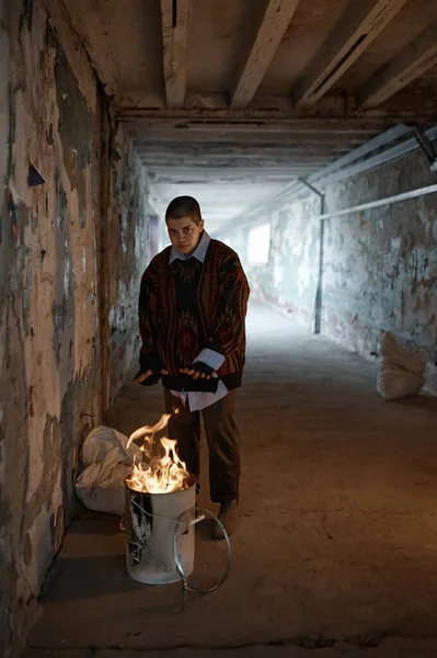 在隧道里 孤独的女乞丐在夜间被火烤着手取暖 不停的场景和燃烧的火焰 — 图库照片