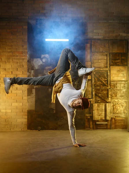 煙とネオンの光の中でダンススタジオの背景を凍結開発ハンサムな若い男 ブレースダンスフリースタイルのパフォーマンスコンセプト — ストック写真