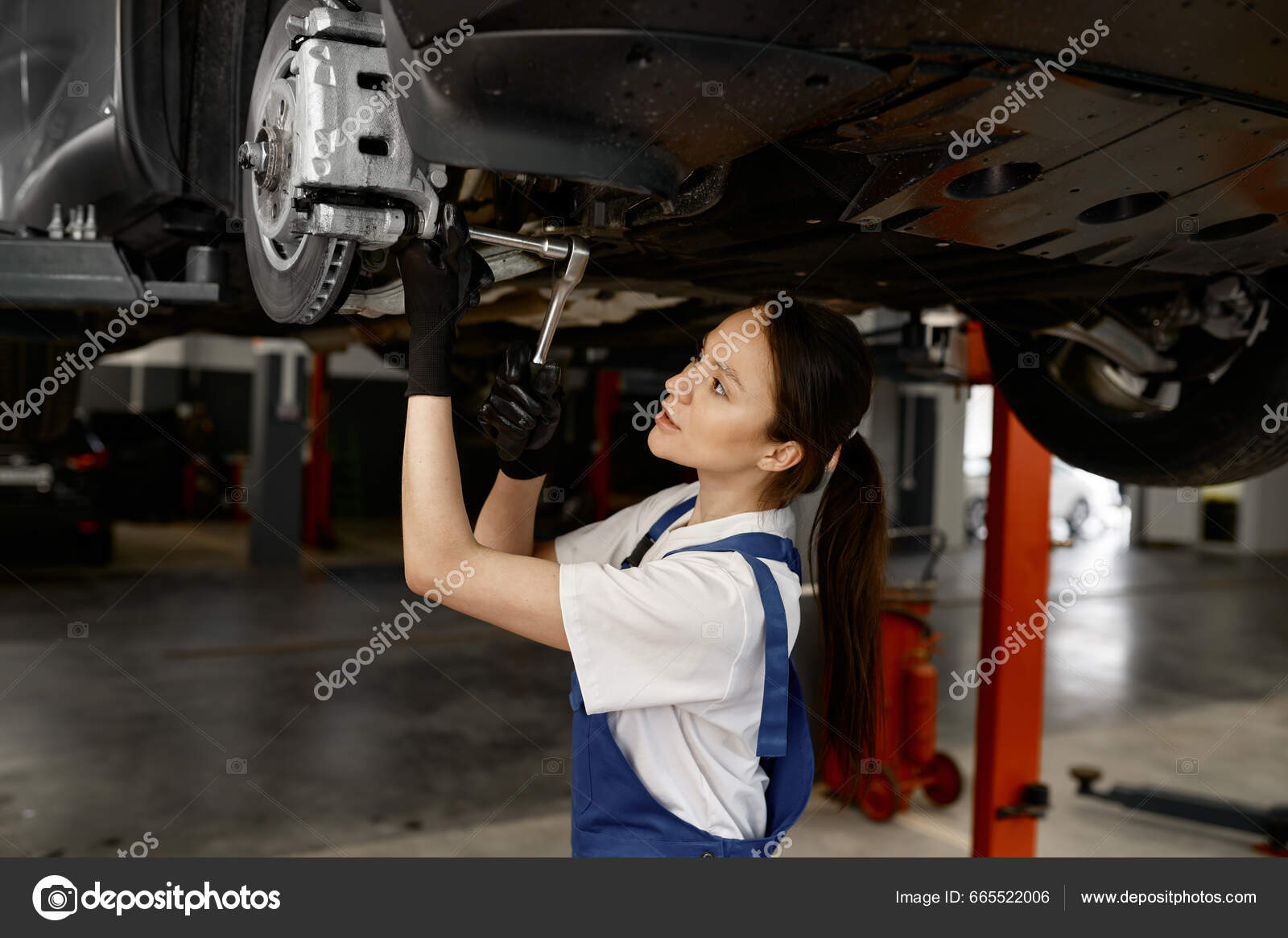 Woman Auto Mechanic Fixing Wheel Hub Disc Brake Raised Car Stock