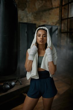 Kickboks bandajlı genç kadın boksörün yakın plan portresi. Havluya sarılı ve antrenmandan sonra yorgun hissediyor. Spor, spor, yaşam tarzı ve insanlar konsepti