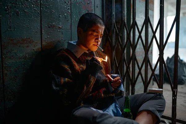 无家可归的女烟民手里拿着香烟看着燃烧的火柴 吸毒成瘾的少女乞丐与希望 — 图库照片