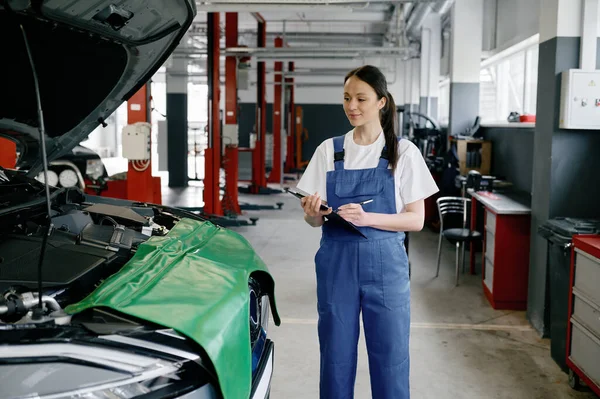 Young Woman Mechanic Car Engineer Wearing Uniform Overalls Writing Clipboard — Stock Photo, Image