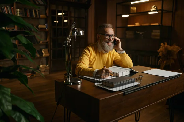 Akşam Evde Çalışırken Gülen Cep Telefonuyla Konuşan Mutlu Yaşlı Bir — Stok fotoğraf