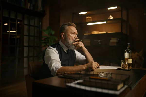 広範囲に圧倒された上級ビジネスマンは 自宅のオフィスでアルコールを飲みながら仕事のテーブルに座っている間にタバコを吸う 悪い考え プロのバーンアウトコンセプト — ストック写真