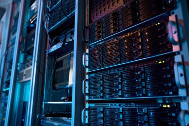 Büyük veri merkezinde süper bilgisayar donanımı ve depolama bıçaklarıyla sunucu rafı. Dijital iletişim ve internet için veritabanı arayüzü ve geçiş