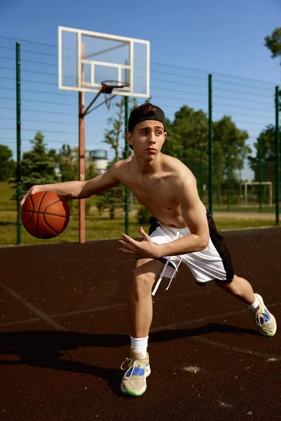 Aktywny Nastoletni Koszykarz Ćwiczący Piłką Boisku Skoncentrowany Chłopiec Gra Miejskim — Zdjęcie stockowe