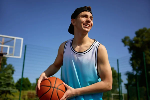 快乐地微笑着的少年篮球运动员 在户外的街头场地上练习球 青少年在城镇体育活动 — 图库照片
