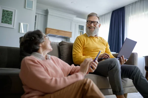 Evdeki Oturma Odasında Dinlenirken Dijital Cihaz Kullanan Gülümseyen Emekli Çift — Stok fotoğraf