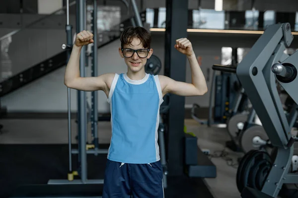 ジムでのトレーニングの後に緊張した腕の筋肉を示すおかしい19歳の少年 双頭のオタクを示す スポーティブオタク スポーツとアクティブな子供時代 — ストック写真