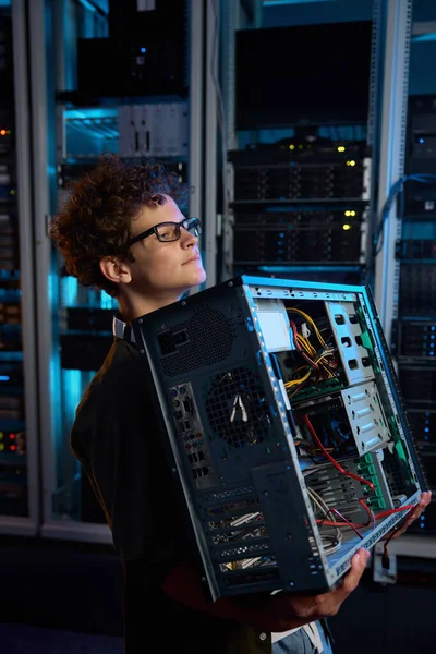 修理サービスとメンテナンスチェックのために準備されたシステムユニットを運ぶ若いティーンエイジャーの学生 データセンターのサーバー室でのネットワーキングエンジニア研修生 — ストック写真