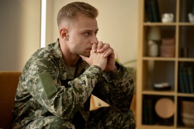 Askeri üniforma giyen üzgün asker zihinsel sağlığını düşünüyor. Psikoterapi ve sosyal sorunlar