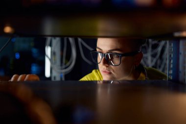 Veri tabanında çalışan genç kadın bilişim mühendisi. Kadın bilişim teknisyeni süper bilgisayarla çalışırken ethernet kablolarını kontrol edip bağlıyor