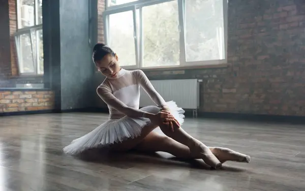在演播室里摆姿势的芭蕾舞女青年坐在地板上 彩排之后 漂亮的才女芭蕾舞演员穿着职业装休息一下 — 图库照片