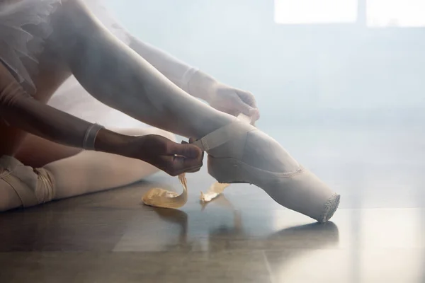 芭蕾舞演员坐在地板上 在上舞蹈课之前穿上尖尖的鞋子 在舞蹈学校准备表演或训练的漂亮女舞蹈演员 — 图库照片