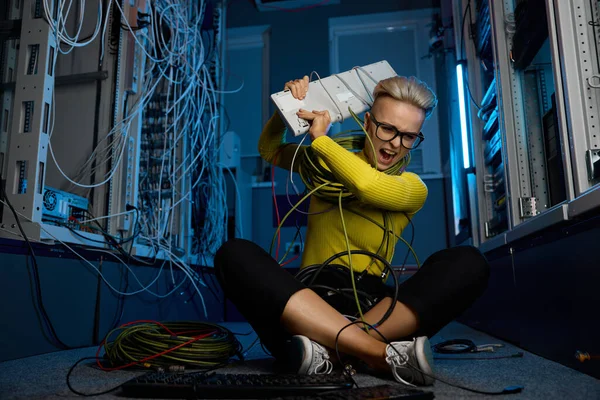 インターネット接続の問題を解決できないため ストレスを感じるコンピュータキーボードを投げる怒っている怒っている女性It技術者 ダークサーバー室内インテリア — ストック写真